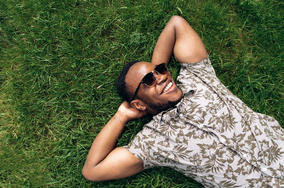 Man in sunglasses laying in grass smiling